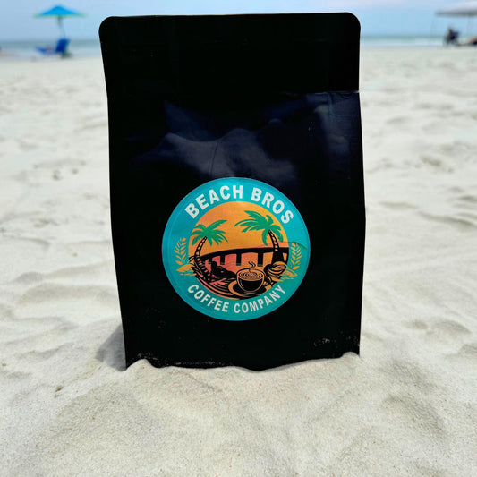 Photo of coffee bag in powder white sand overlooking water